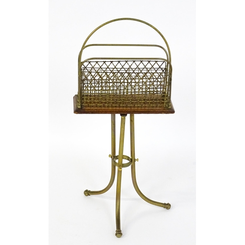 1508 - A mid 20thC Canterbury with a hoop handle above three grilled dividers raised on three brass legs. 3... 