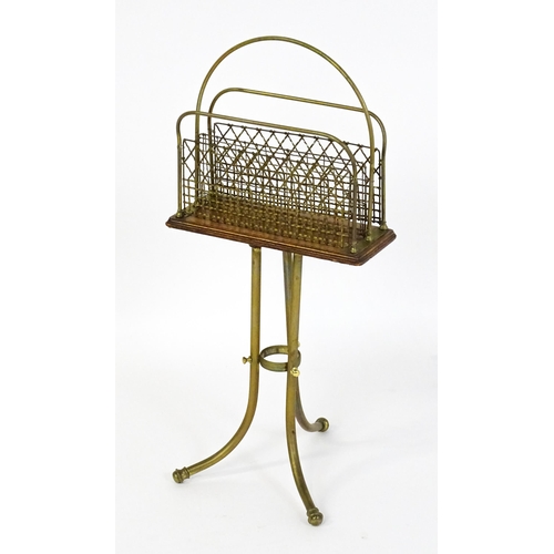 1508 - A mid 20thC Canterbury with a hoop handle above three grilled dividers raised on three brass legs. 3... 