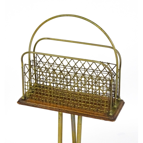 1508 - A mid 20thC Canterbury with a hoop handle above three grilled dividers raised on three brass legs. 3... 