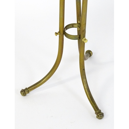 1508 - A mid 20thC Canterbury with a hoop handle above three grilled dividers raised on three brass legs. 3... 