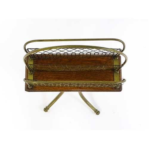 1508 - A mid 20thC Canterbury with a hoop handle above three grilled dividers raised on three brass legs. 3... 