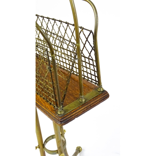 1508 - A mid 20thC Canterbury with a hoop handle above three grilled dividers raised on three brass legs. 3... 