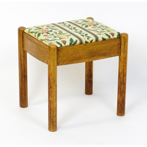 1553 - A mid 20thC Cotswold School stool with a drop in seat raised on four canted legs. 19 1/2