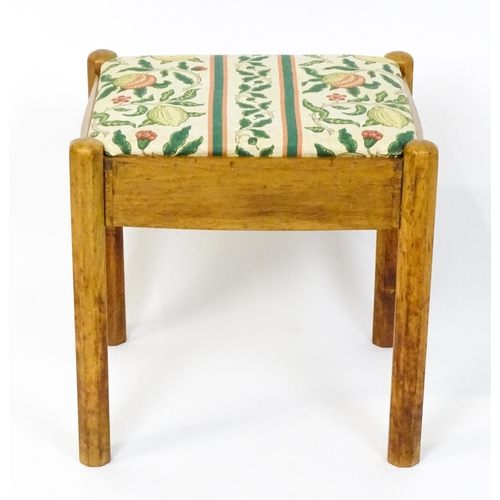 1553 - A mid 20thC Cotswold School stool with a drop in seat raised on four canted legs. 19 1/2