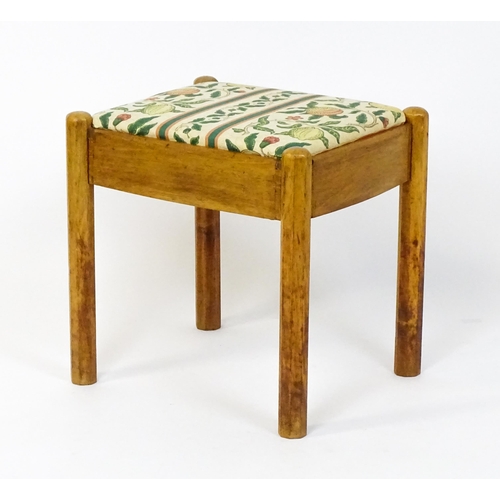 1553 - A mid 20thC Cotswold School stool with a drop in seat raised on four canted legs. 19 1/2