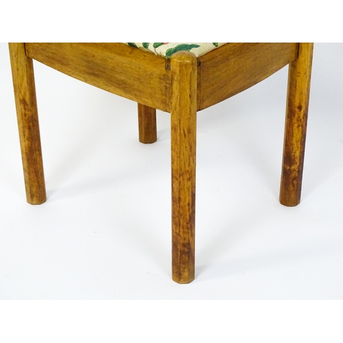 1553 - A mid 20thC Cotswold School stool with a drop in seat raised on four canted legs. 19 1/2