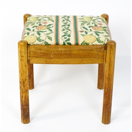 1553 - A mid 20thC Cotswold School stool with a drop in seat raised on four canted legs. 19 1/2