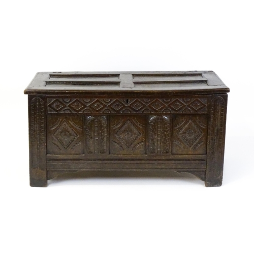 1602 - A late 17thC oak coffer with a triple panelled front with lozenge carved panels and rails raised on ... 