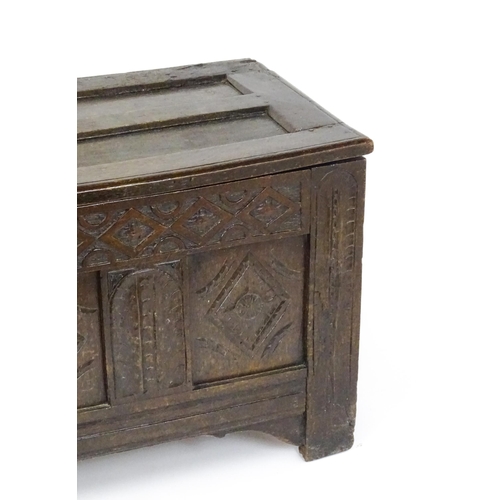 1602 - A late 17thC oak coffer with a triple panelled front with lozenge carved panels and rails raised on ... 