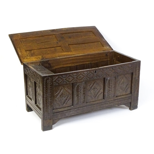 1602 - A late 17thC oak coffer with a triple panelled front with lozenge carved panels and rails raised on ... 