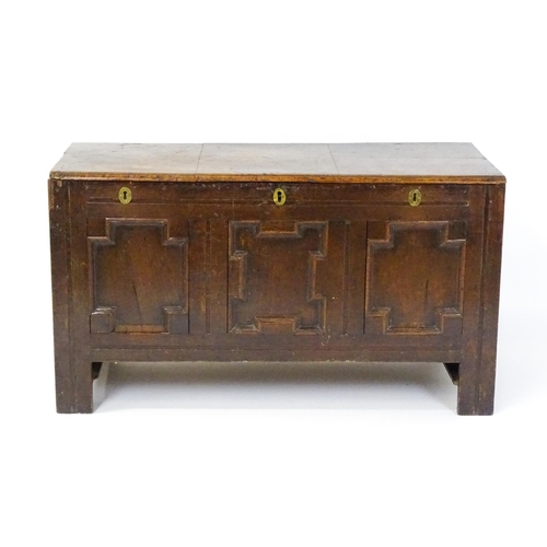 1626 - A late 17thC oak coffer with three geometrically moulded panels raised on stile feet. 48