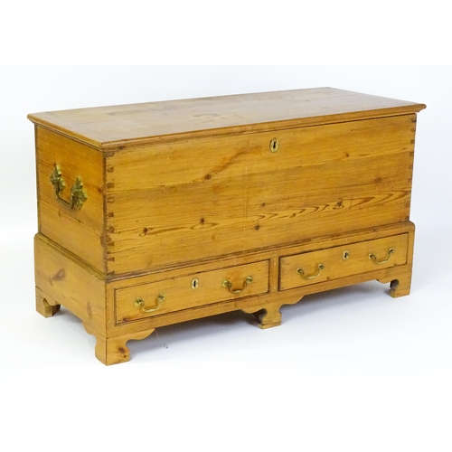 1627 - A 19thC pine mule chest with a hinged lid above two short drawers raised on shaped bracket feet and ... 