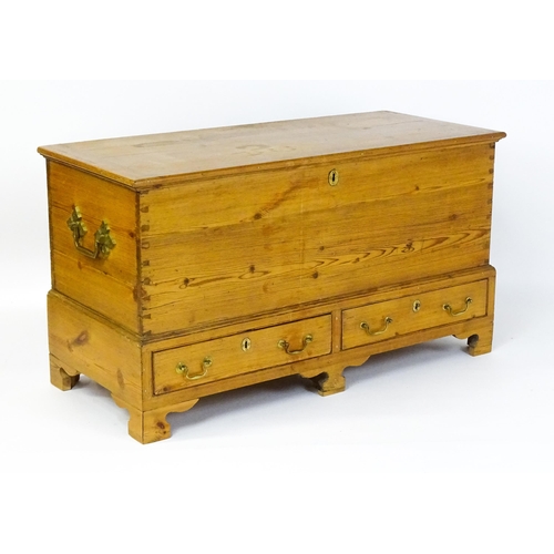 1627 - A 19thC pine mule chest with a hinged lid above two short drawers raised on shaped bracket feet and ... 