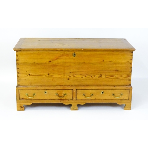 1627 - A 19thC pine mule chest with a hinged lid above two short drawers raised on shaped bracket feet and ... 