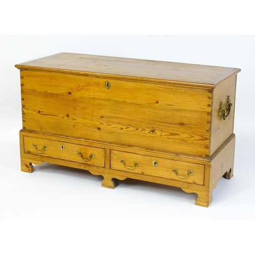 1627 - A 19thC pine mule chest with a hinged lid above two short drawers raised on shaped bracket feet and ... 