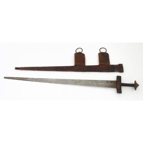 835 - Militaria : an early 20thC North African Tuareg takoba sword and scabbard , the leather covered hilt... 