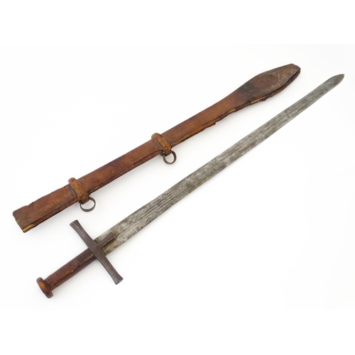 839 - Militaria : an early 20thC Sudanese Kaskara sword and scabbard, the leather covered handle with disc... 