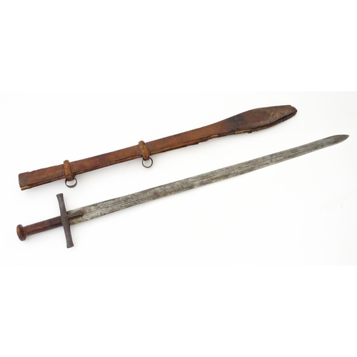 839 - Militaria : an early 20thC Sudanese Kaskara sword and scabbard, the leather covered handle with disc... 