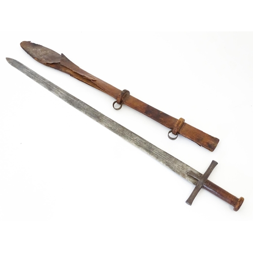 839 - Militaria : an early 20thC Sudanese Kaskara sword and scabbard, the leather covered handle with disc... 