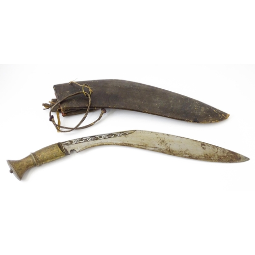 846 - An early to mid 20thC Kukri / Khukuri knife and leather sheath , the brass sectional hilt and steel ... 