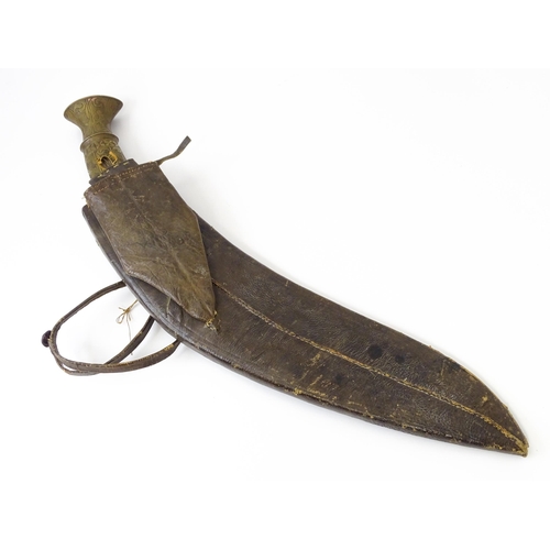 846 - An early to mid 20thC Kukri / Khukuri knife and leather sheath , the brass sectional hilt and steel ... 