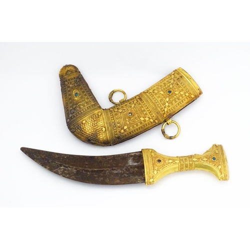 849 - An early 20thC Yemeni Jambiya dagger and sheath, the steel blade with yellow metal hilt decorated wi... 