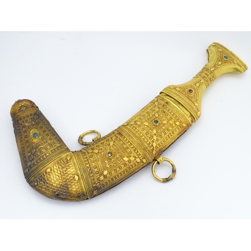 849 - An early 20thC Yemeni Jambiya dagger and sheath, the steel blade with yellow metal hilt decorated wi... 