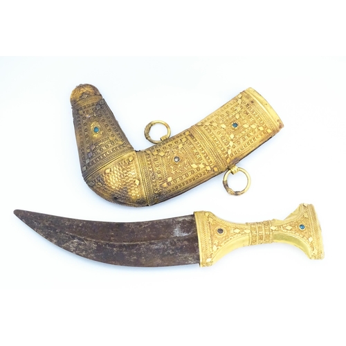 849 - An early 20thC Yemeni Jambiya dagger and sheath, the steel blade with yellow metal hilt decorated wi... 