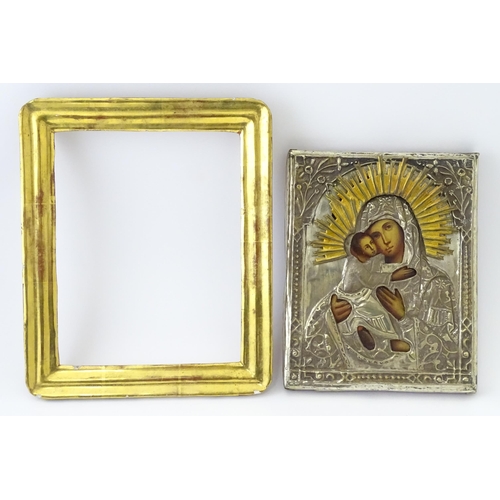 1054 - A 19thC Russian oil on panel icon depicting Madonna and Child with an embossed white metal surround ... 