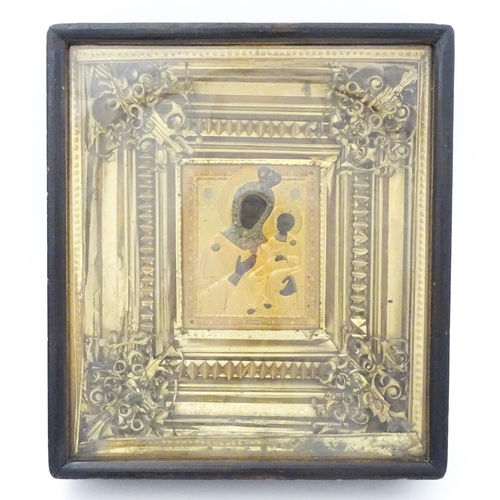 1055 - A 19thC Russian icon depicting Madonna and Child with an embossed gilt metal surround bordered by an... 