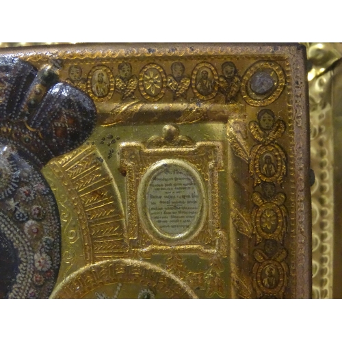 1055 - A 19thC Russian icon depicting Madonna and Child with an embossed gilt metal surround bordered by an... 