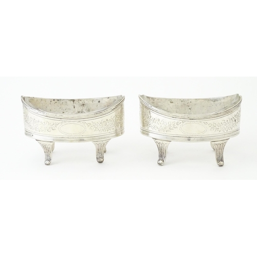 379A - A pair of George IV silver salts with bright cut decoration, and raised on four feet, with clear gla... 