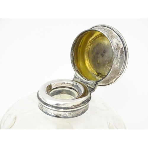 489A - A glass  dressing table scent / perfume bottle raised on four glass bun feet, the silver top hallmar... 