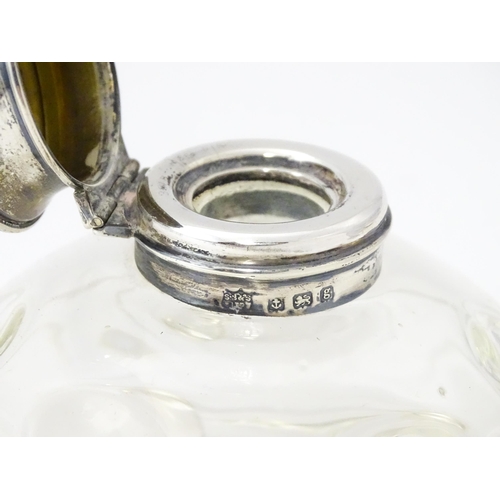 489A - A glass  dressing table scent / perfume bottle raised on four glass bun feet, the silver top hallmar... 