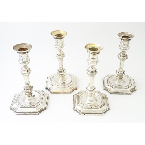 595 - A matched set of four silver candlesticks  hallmarked Sheffield 1894 and 1907, maker Hawksworth, Eyr... 