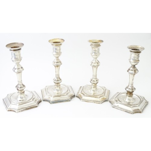 595 - A matched set of four silver candlesticks  hallmarked Sheffield 1894 and 1907, maker Hawksworth, Eyr... 