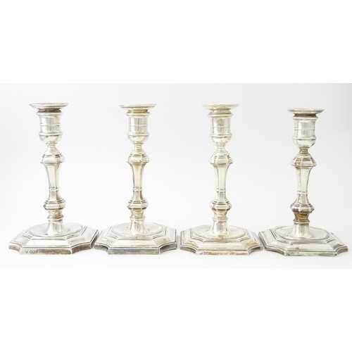 595 - A matched set of four silver candlesticks  hallmarked Sheffield 1894 and 1907, maker Hawksworth, Eyr... 