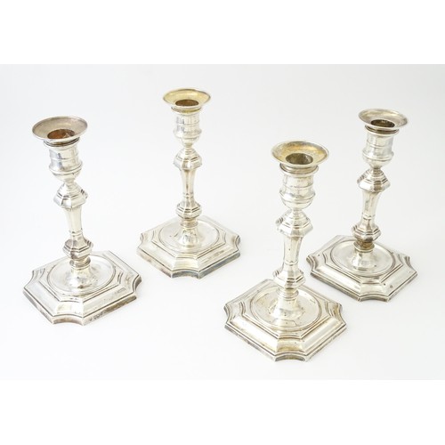 595 - A matched set of four silver candlesticks  hallmarked Sheffield 1894 and 1907, maker Hawksworth, Eyr... 