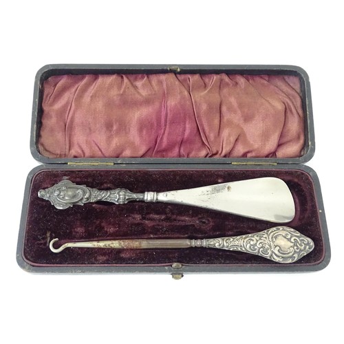 570 - A silver handled button hook hallmarked Chester 1921. Together with a silver handled shoe horn hallm... 