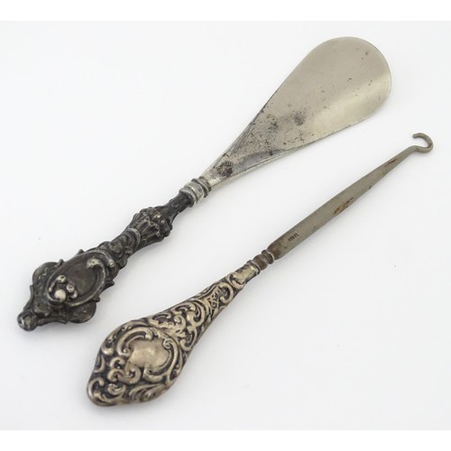 570 - A silver handled button hook hallmarked Chester 1921. Together with a silver handled shoe horn hallm... 