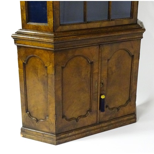 1499 - A late 19thC walnut cabinet with a moulded cornice above an astragal glazed door containing three pa... 