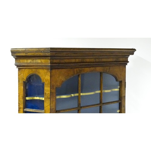 1499 - A late 19thC walnut cabinet with a moulded cornice above an astragal glazed door containing three pa... 