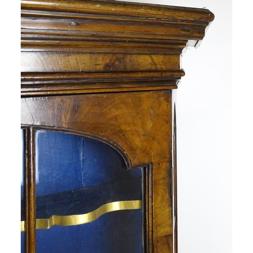 1499 - A late 19thC walnut cabinet with a moulded cornice above an astragal glazed door containing three pa... 