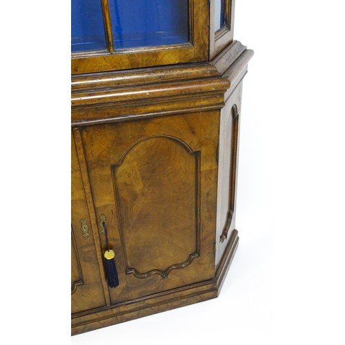 1499 - A late 19thC walnut cabinet with a moulded cornice above an astragal glazed door containing three pa... 