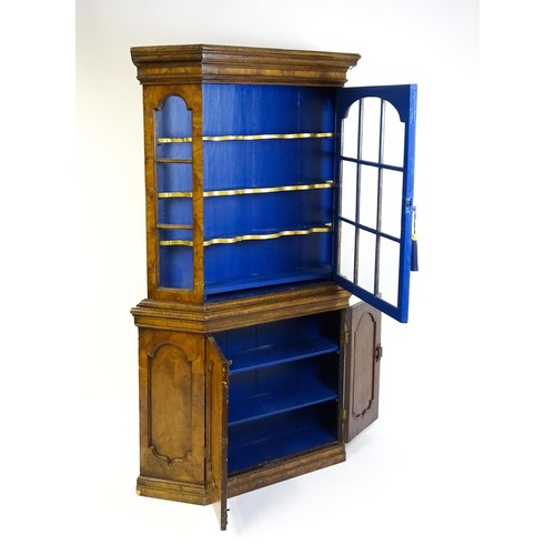 1499 - A late 19thC walnut cabinet with a moulded cornice above an astragal glazed door containing three pa... 