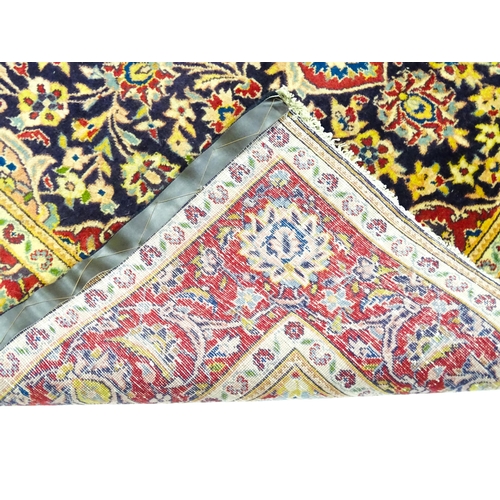 1358 - Carpet / Rug : A North West Persian Sarouk rug the red and blue ground with central floral vignette ... 