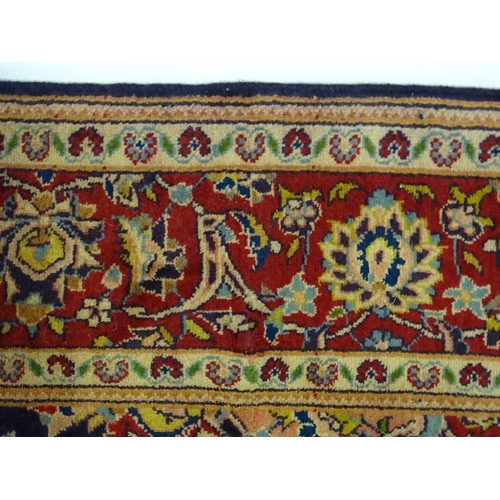 1358 - Carpet / Rug : A North West Persian Sarouk rug the red and blue ground with central floral vignette ... 