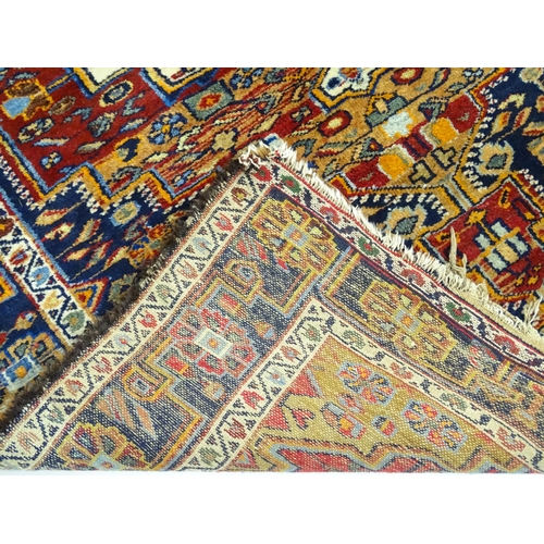 1363 - Carpet / Rug : A blue and red ground rug with floral and geometric motifs, with banded borders. Appr... 