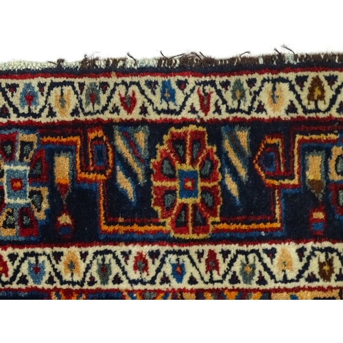 1363 - Carpet / Rug : A blue and red ground rug with floral and geometric motifs, with banded borders. Appr... 