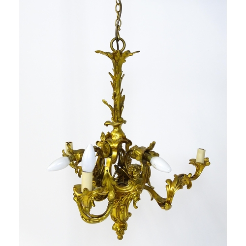 1435 - A gilt metal pendant chandelier / electrolier with acanthus scroll and cherub detail, having three c... 